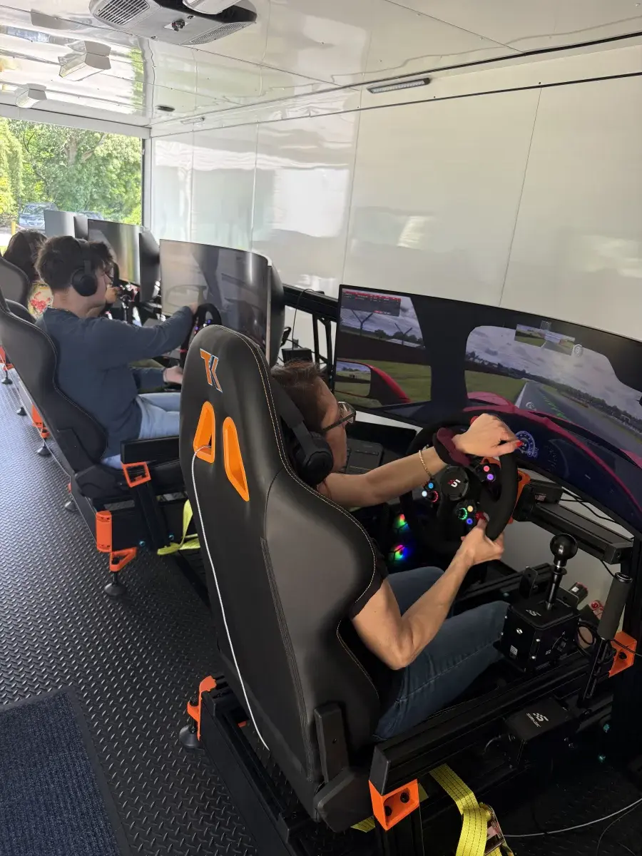 Teen gripping racing wheel in trailer